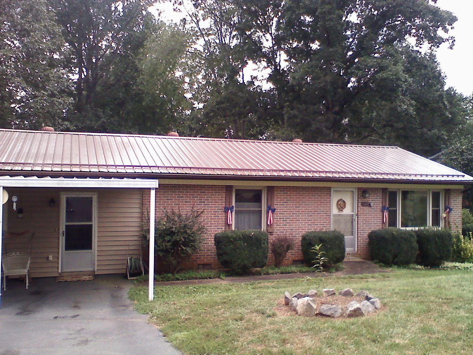 Bronze metal roof and carport on a brick ranch home — Roof Repair work by our crew in Piedmont